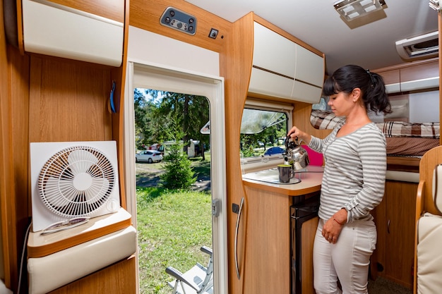 Woman cooking in camper, motorhome interior VR. Family vacation travel, holiday trip in motorhome, Caravan car Vacation.