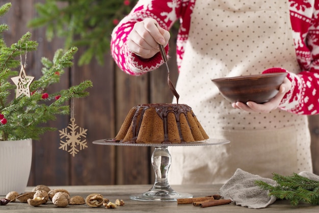 Woman cooking christmas cake on wood kitchen