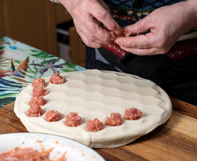 Woman cooking delicious homemade dumplings on the kitchen at home