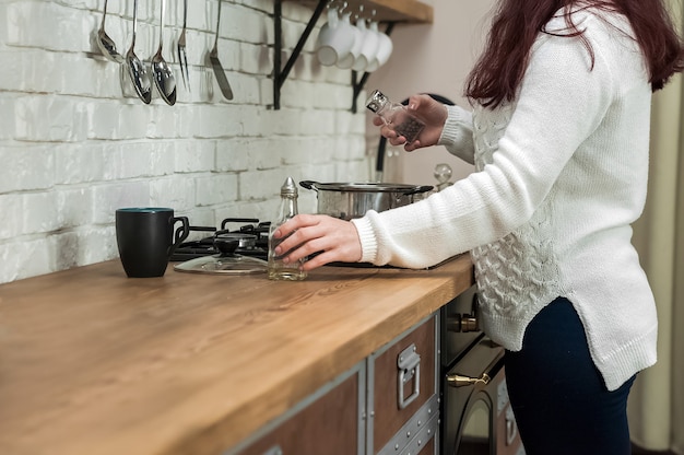 Donna che cucina delizioso vin brulè al primo piano della stufa.