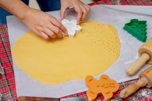 Woman cooking gingerbread on winter holiday at home. Homemade Xmas cookie for Christmas and Happy New Year.