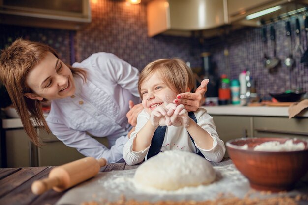 Donna che cucina e si diverte con la bambina