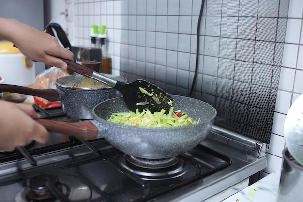 Woman cooking healthy vegetables on pan in the kitchen