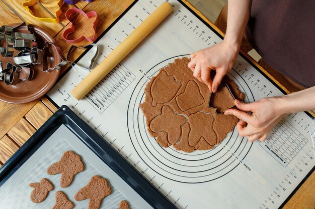 A woman cooking holiday homemade cookies on a silicone baking mat Top view