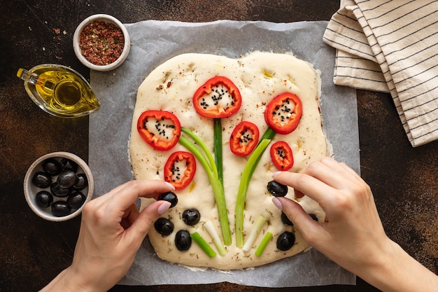 Woman cooking Italian focaccia bread with vegetables and herbs art focaccia