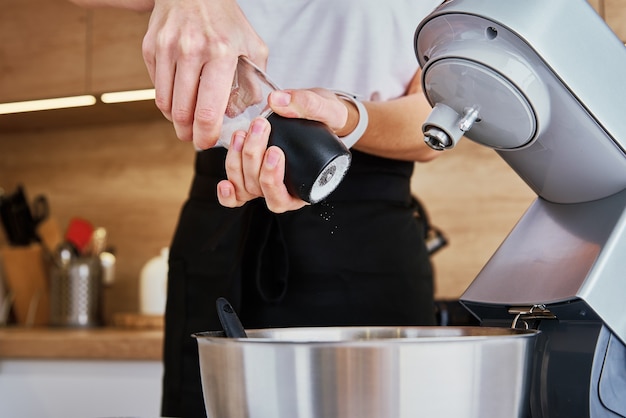 Woman cooking at kitchen and using kitchen machine