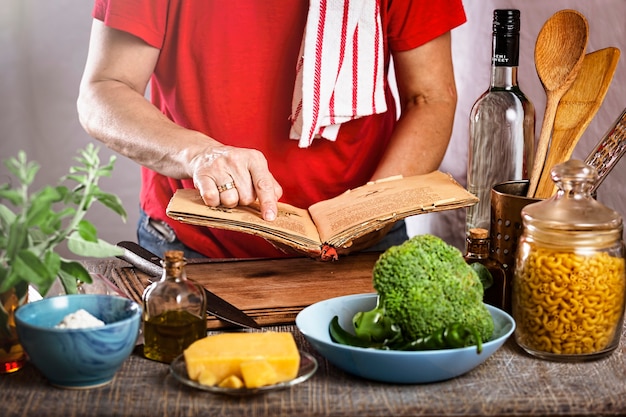 Foto donna che cucina la pasta con salsa di panna bianca a casa in cucina