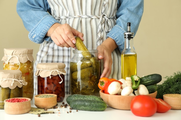 Woman cooking pickled cucumbers and different vegetables