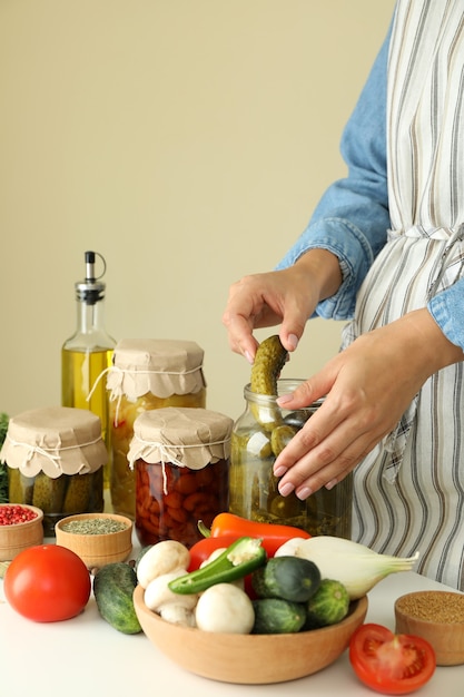 Woman cooking pickled cucumbers and different vegetables