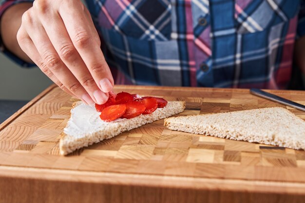 Woman cooking sandwiches toast with a fresh berries in the kitchen