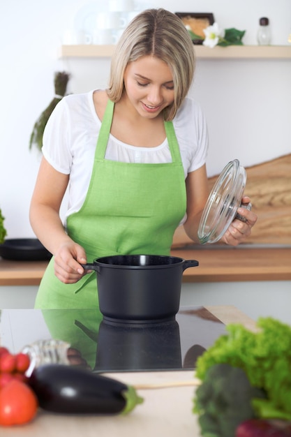 Woman cooking soup in kitchen Healthy meal and culinary concept