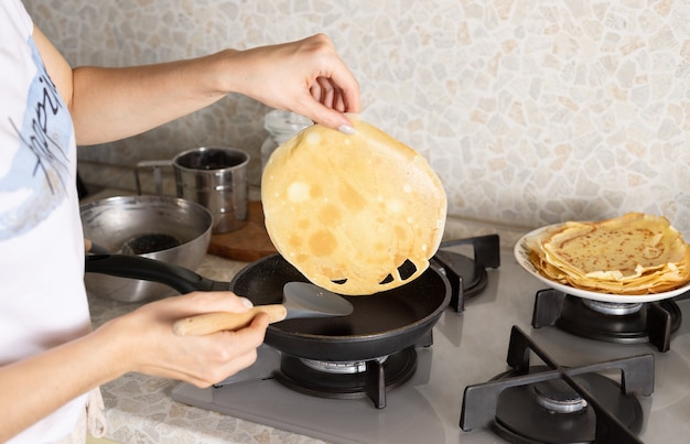 Woman cooking thin pancakes