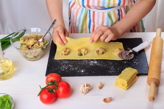 Donna che cucina i ravioli italiani fatti in casa tradizionali