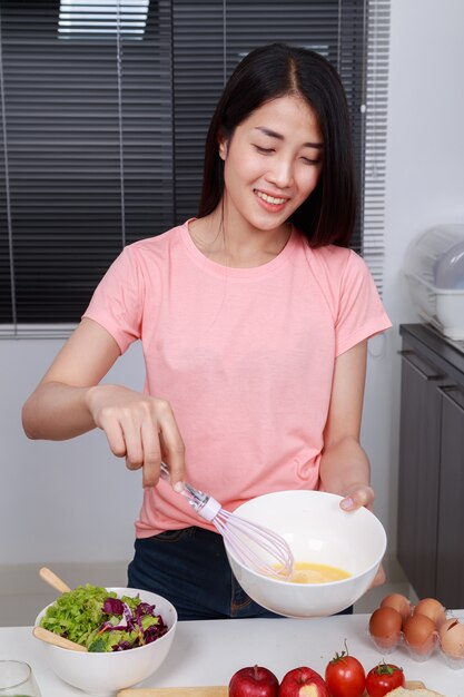 여자 요리와 부엌에서 그릇에 계란을 내 쫓기