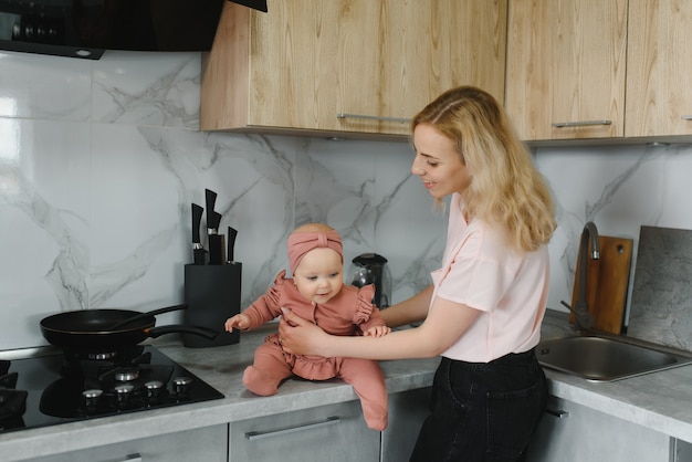 Woman cooking with her little daughter in hands