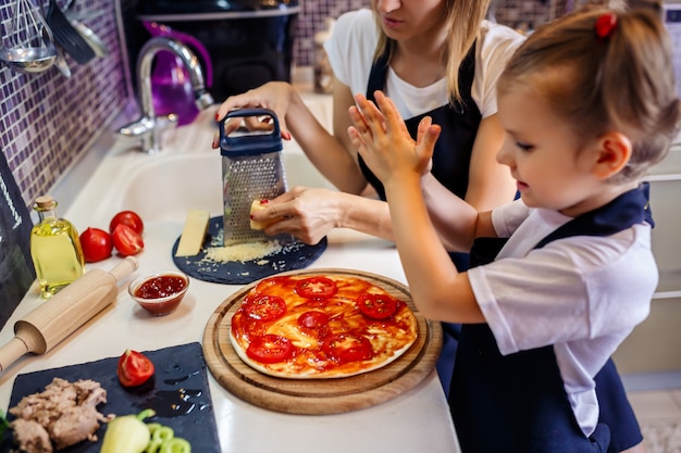 Woman cooking with little girl