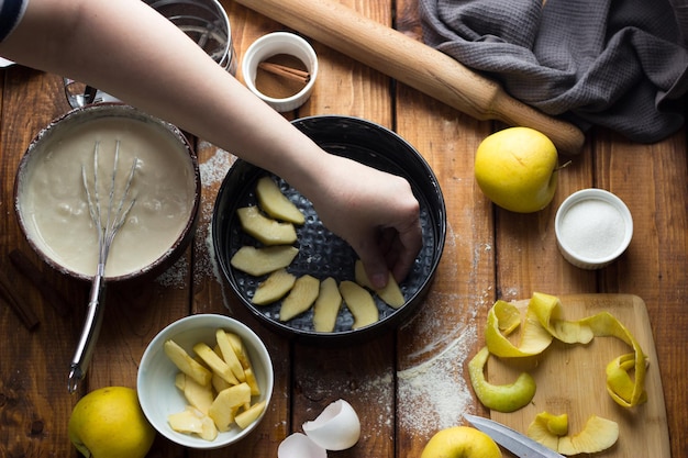 A woman cooks an apple pie on a wooden table. The process of making a pie.