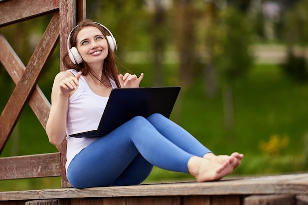 Woman in cordless headphones listens to music outdoors