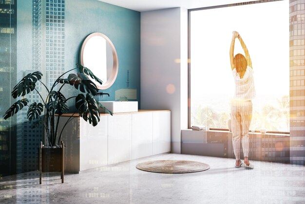Photo woman in corner of modern bathroom with dark green walls, concrete floor, sink standing on white countertop and round mirror. toned image double exposure