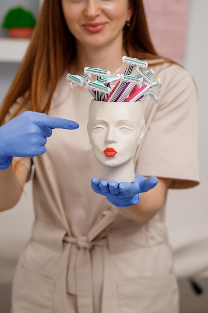 Woman cosmetologist holding vase with razors from plastic for shaving legs