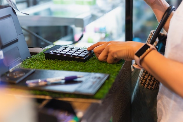 Photo woman costomer enters the amount into the cash register in cafe