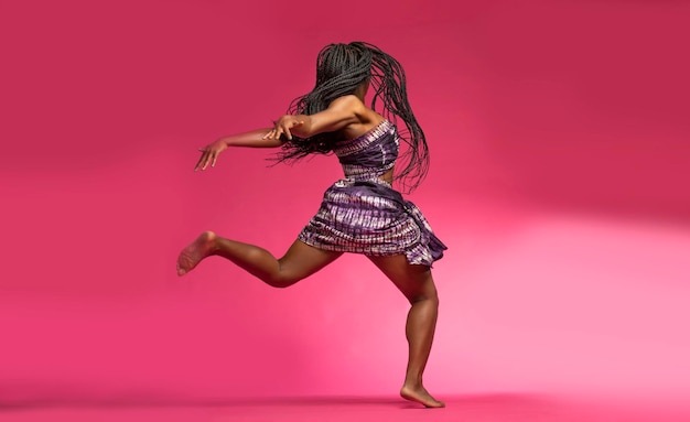 Photo woman in costume dancing against pink background