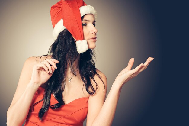 Woman in costume of Santa Claus showing to copy space