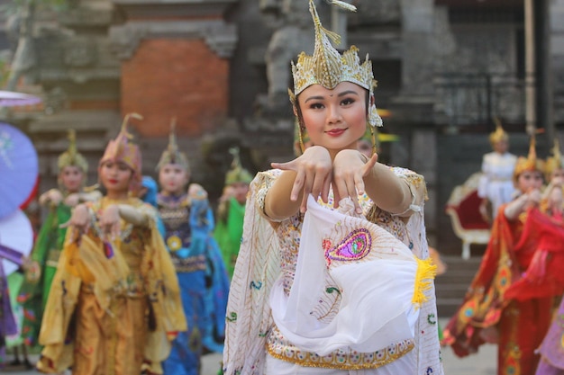 a woman in a costume with a butterfly on her head stands in front of a temple.