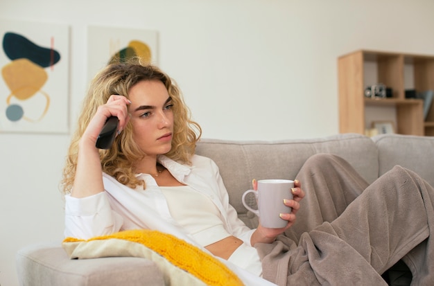 Photo woman on couch watching tv side view