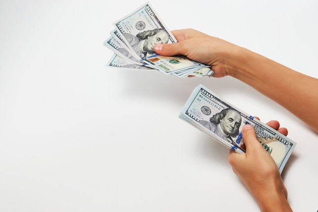 Woman counting dollars money, top view. hands holding a dollar
bills on white background, close-up. salary, earning and savings
concept