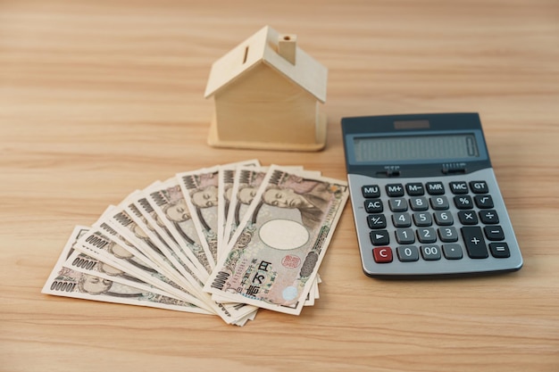 Woman counting Japanese Yen banknote with House model Real Estate Home Mortgage Japan cash Tax Recession Economy Inflation Investment finance and savings concepts