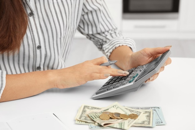 Woman counting taxes at table closeup