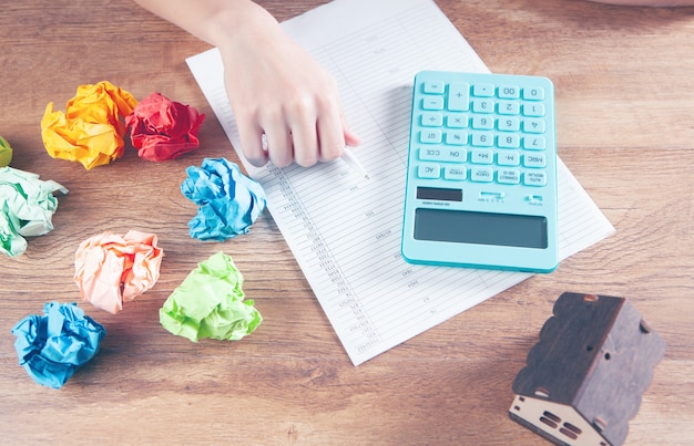 woman counts on a calculator in front of the house