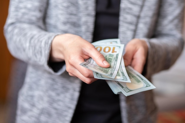 Woman counts money female hands hold cash banknotes denominations of 100 dollars currency