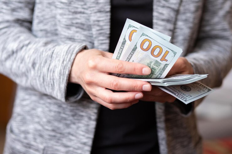 Photo 女性はお金を数えます女性の手は100ドルの通貨の現金紙幣を持っています