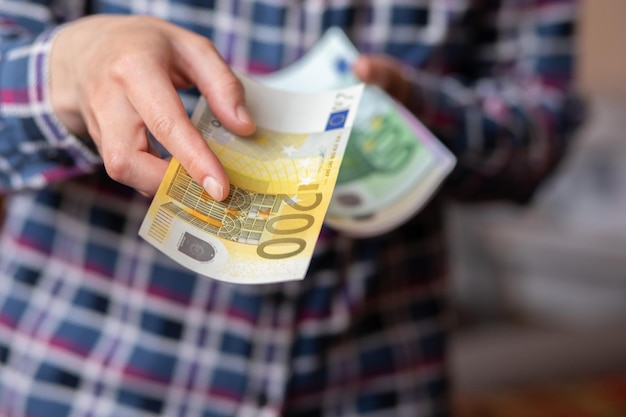 Фото Женщина считает деньги, женские руки держат наличные банкноты номиналом 200 евро