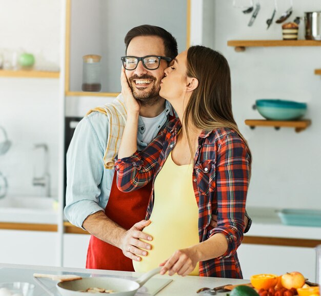 Photo woman couple man pregnant food cooking preparing ingredient kitchen pregnancy happy love fresh diet