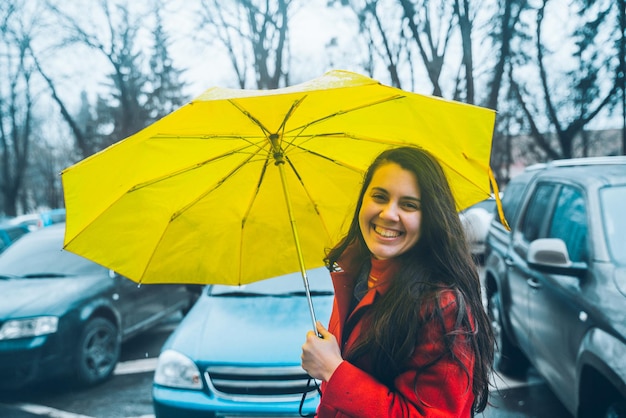 Woman cover with yellow umbrella in windy weather. storm alarm