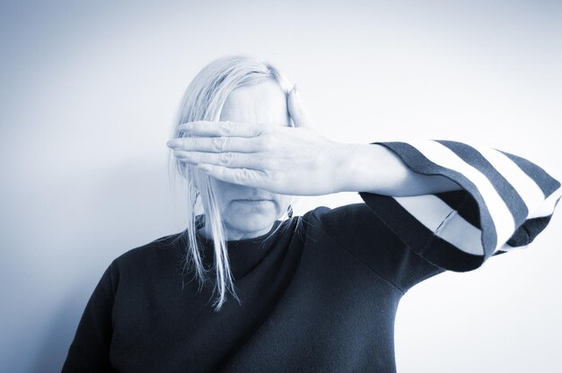 Photo woman covering eyes against white background