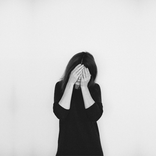 woman covering eyes with hands