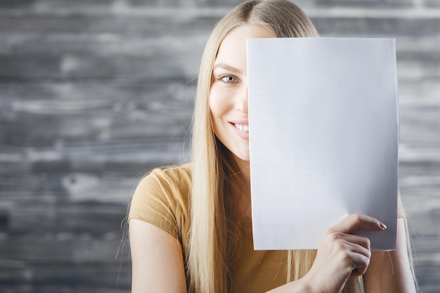 Woman covering face with empty paper