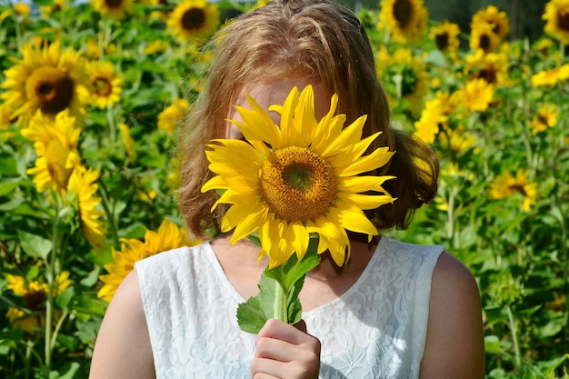 Woman covering face with sunflower