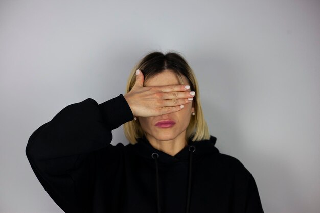 Photo woman covering her eyes isolated on a gray background