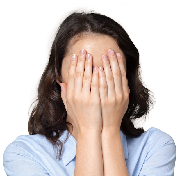 Woman covering her face with both hands