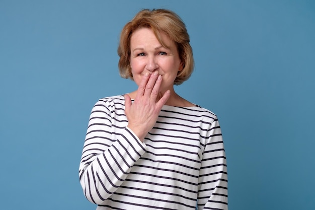 Woman covering mouth with hand She head a funny news about her coworker