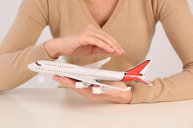 Foto donna che copre l'aereo giocattolo al primo piano del tavolo concetto di assicurazione di viaggio