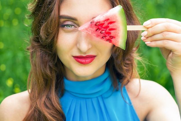 Woman covers eye with watermelon.