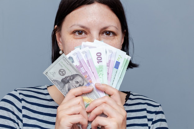 Woman covers face with banknotes