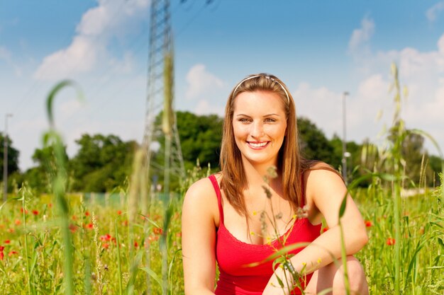 フィールドの牧草地でcowする女性