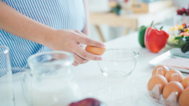 Foto donna che fende un uovo in una ciotola